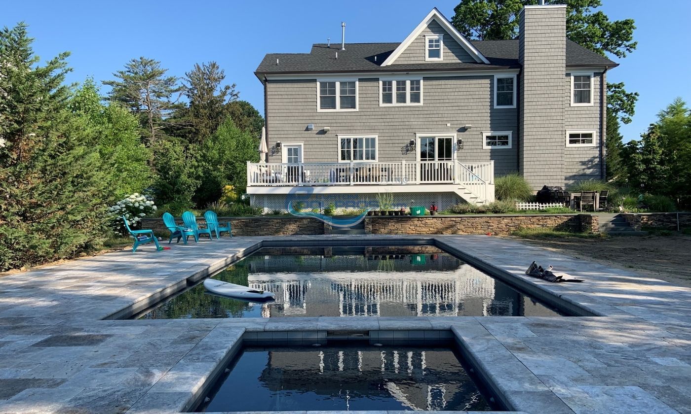 The Allure of a Spacious Poolside with a Stone-Like Surface in Watchung